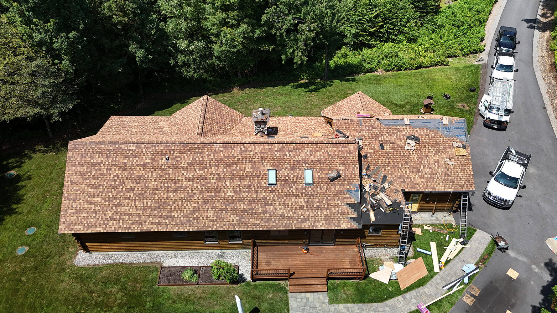 Crew installing CertainTeed Landmark Pro shingles with skylights Underhill Vermont aerial