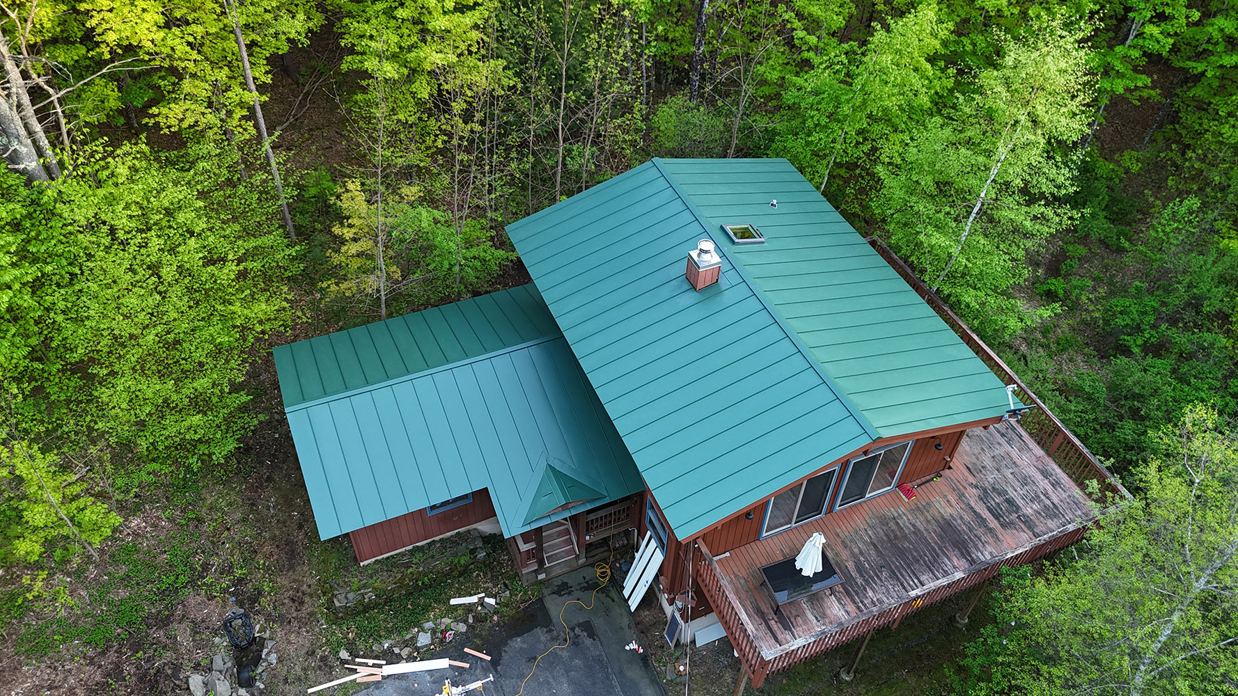 Englert forest green standing seam metal roof — Stowe Vermont cedar home and attached garage aerial view