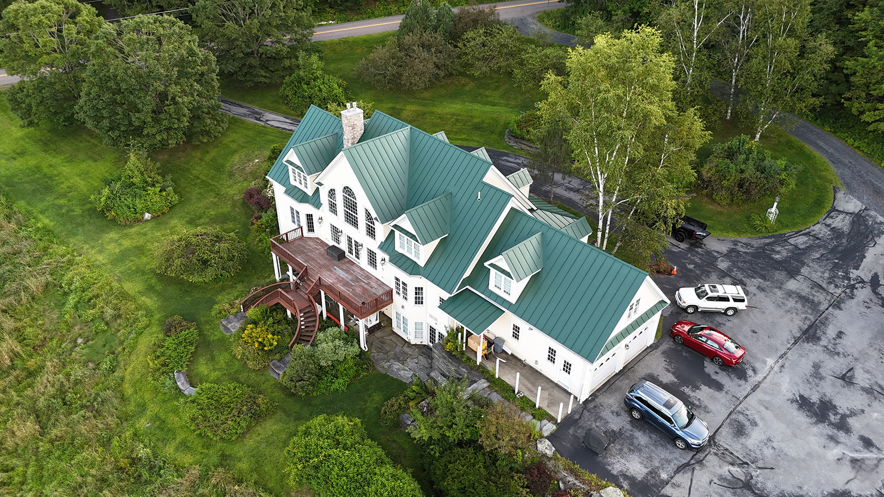 Englert forest green standing seam metal roof luxury estate Waterbury Vermont completed aerial