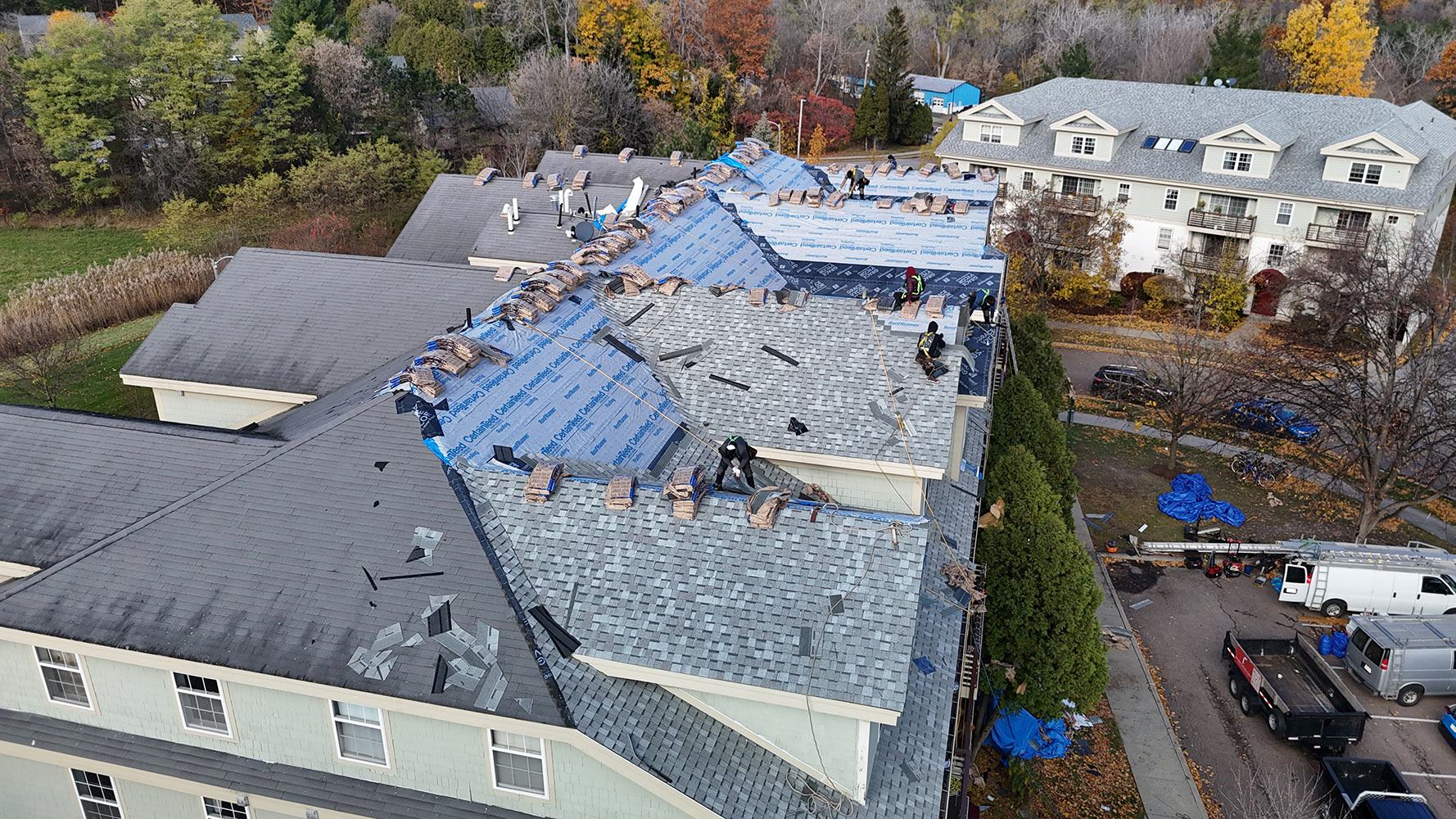 Aerial view of Rivers Construction crew installing shingles on River Watch Condominiums Building 1, Burlington Vermont